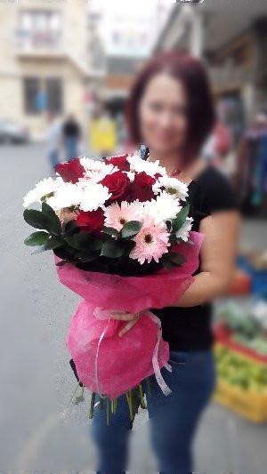 Девушка с букетом из белых ромашек, розовых хризантем и красных роз